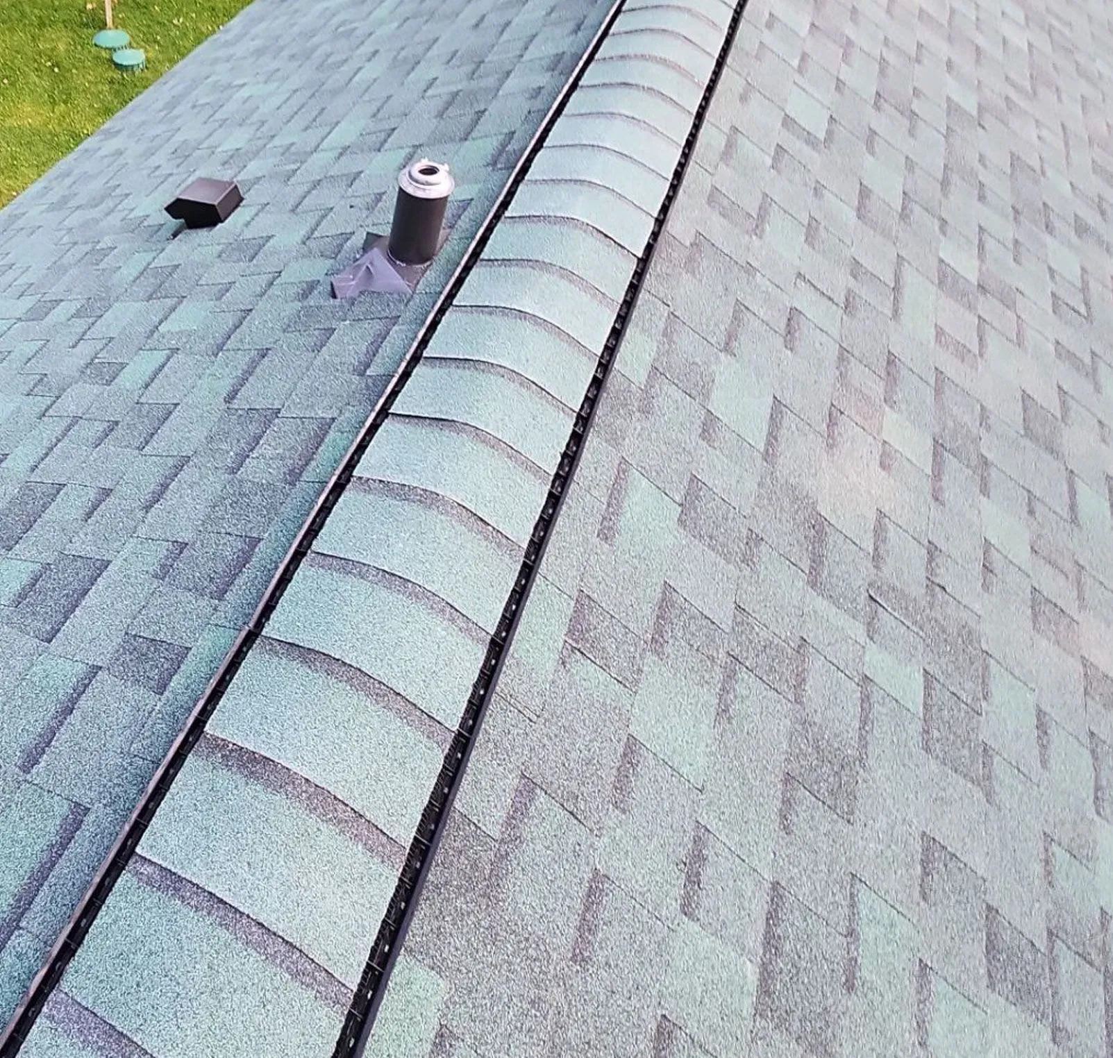 Completed asphalt shingle roof with ridge caps and roof vents