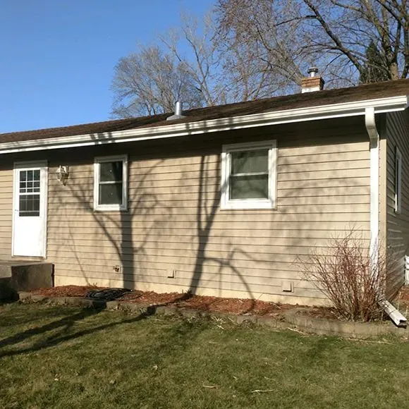 Completed full siding replacement with tan horizontal siding and white exterior trim