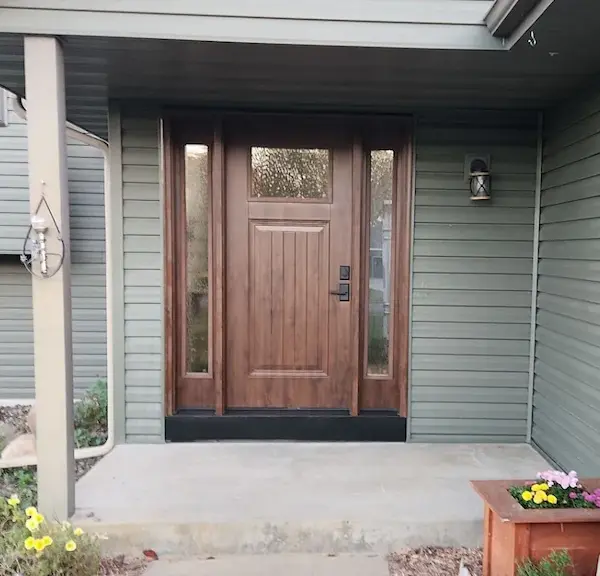 New wood-finish front entry door with glass sidelights installed at a home near Zimmerman, Minnesota