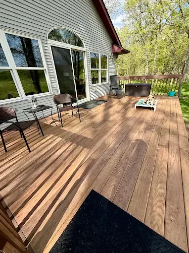 Repaired and refinished wood deck behind a residential home