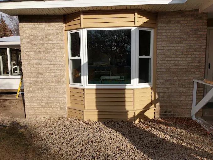 New white bay window installed in a residential brick exterior