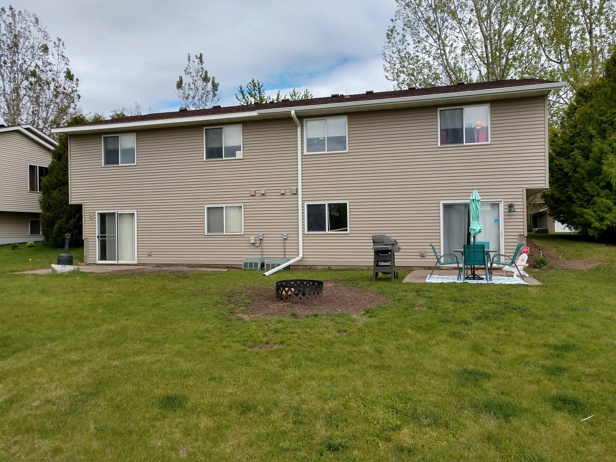Completed full siding replacement with tan horizontal siding on a multi-level home